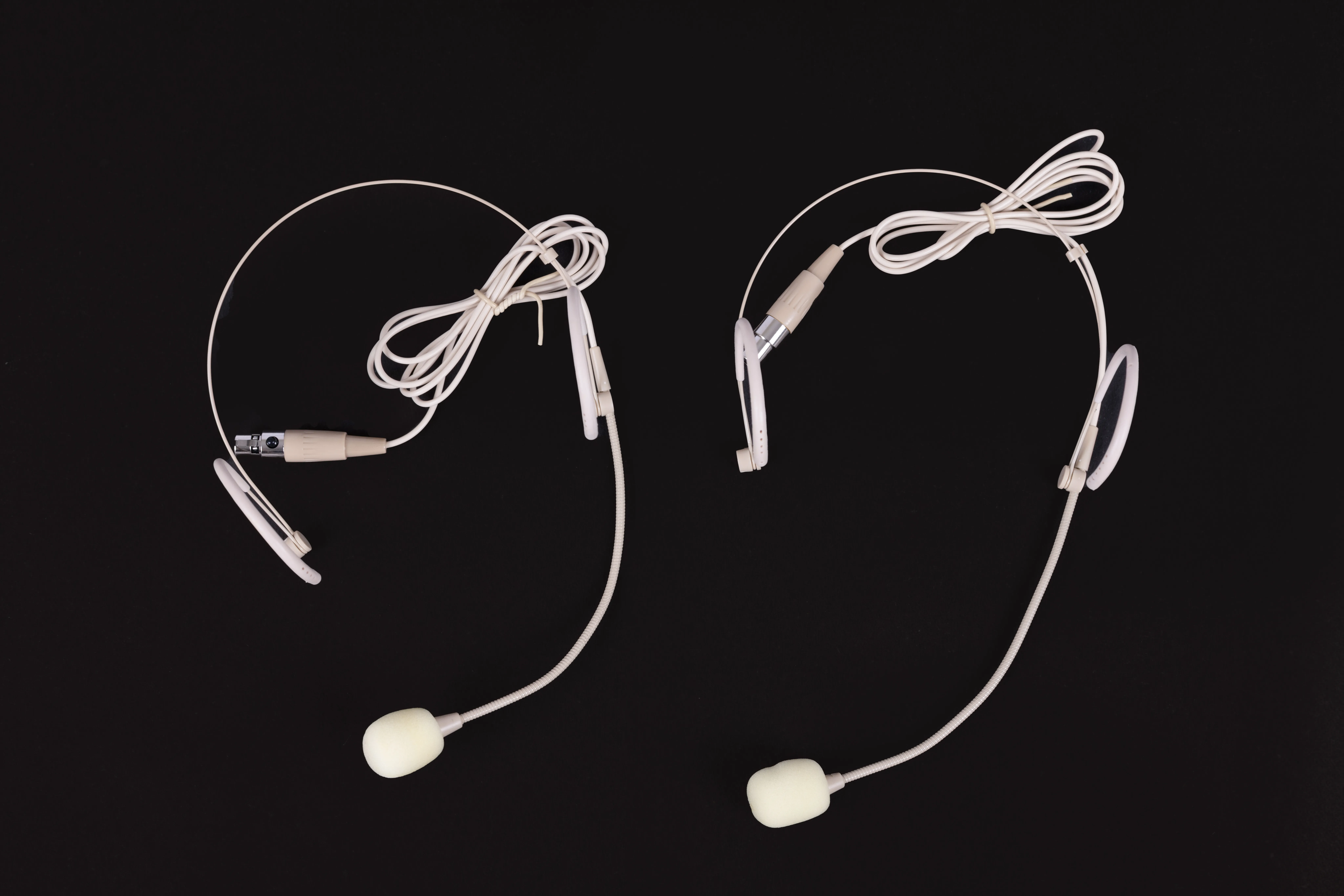 Close-up of two professional headset microphones with flexible boom arms